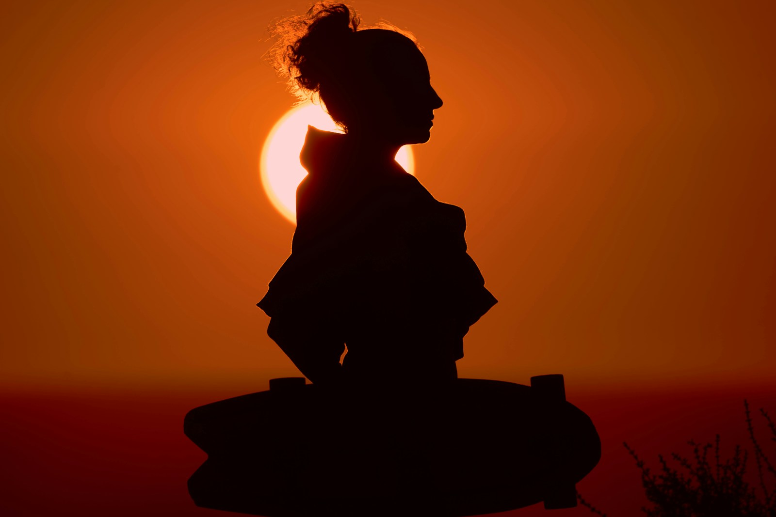 Person in Meditationspose mit sanftem Sonnenuntergangslicht