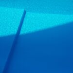 Ruhige Wasseroberfläche mit konzentrischen Ringen, in denen sich das Licht in feinen Streifen bricht