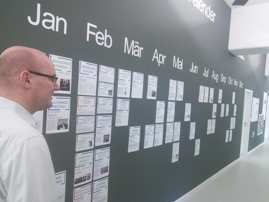 Monatskalender an einer Wand, einzelne Tage mit kurzen Notizen in den Feldern versehen