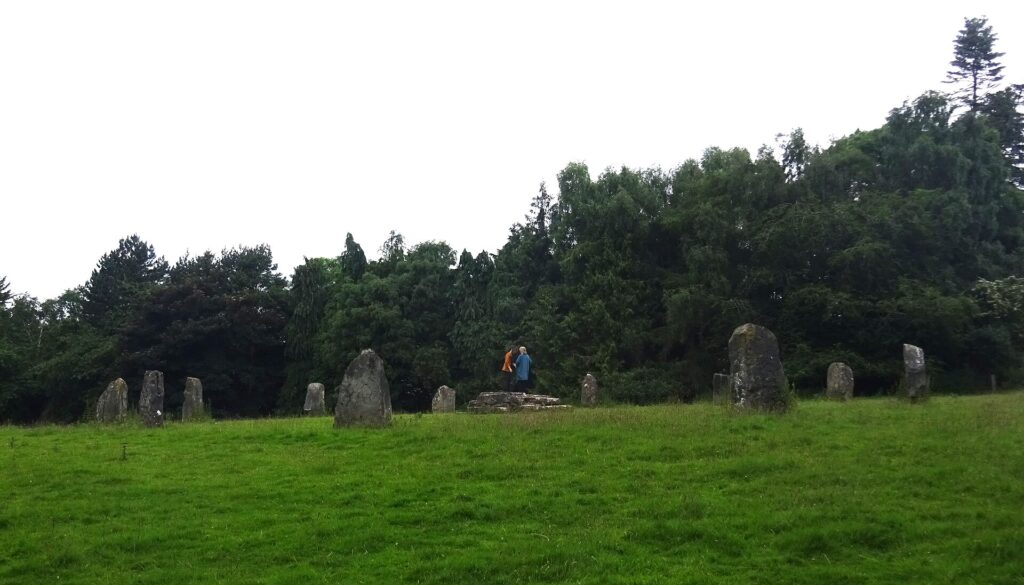 Aufrecht stehende Steine in einem Kreis auf einer offenen Wiese im Herbst
