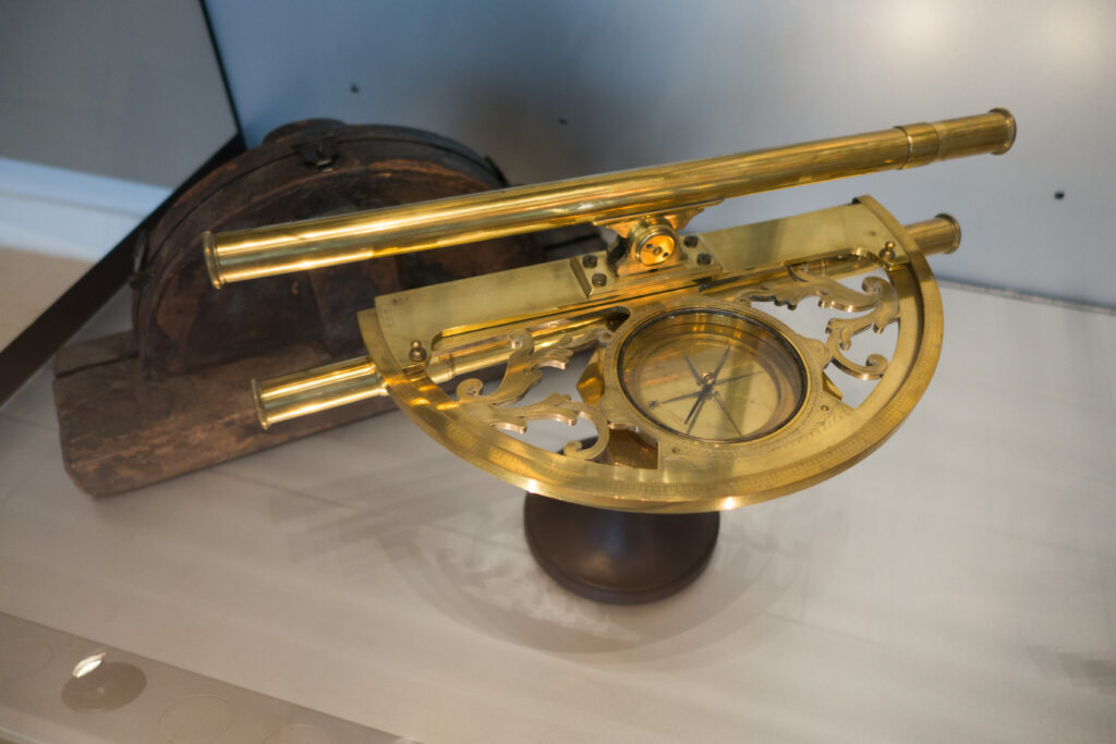 Messingsextant mit Gradbogen und Ablesevorrichtung auf einer hölzernen Tischplatte
