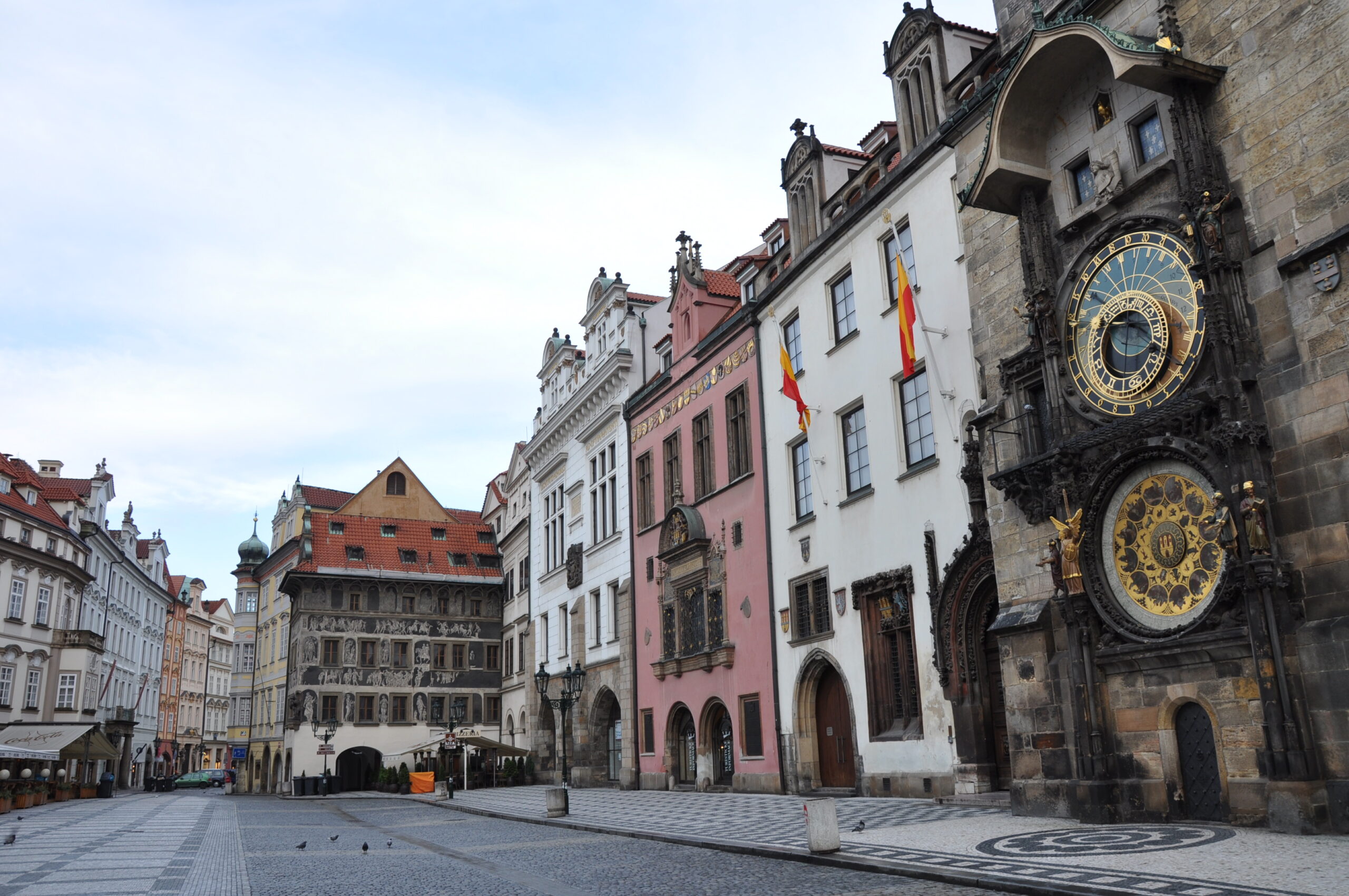 Historische astronomische Uhr mit mehreren Zeigern und beschrifteten Ringen an einer Fassade