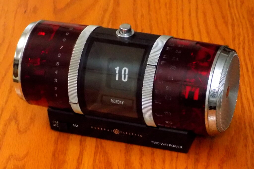 Aufgeschlagener Kalender auf einem Schreibtisch neben einem Stift und einer Uhr